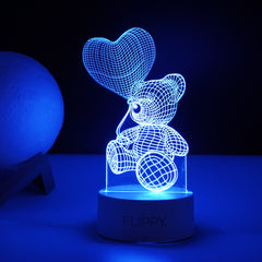 Lampa LED decorativa, Kaveny, 3D, Ursulet cu balon inima, cu telecomanda, doua moduri de alimentare USB si baterii, 20 cm inaltime, din material acril si lumina multicolora, alb