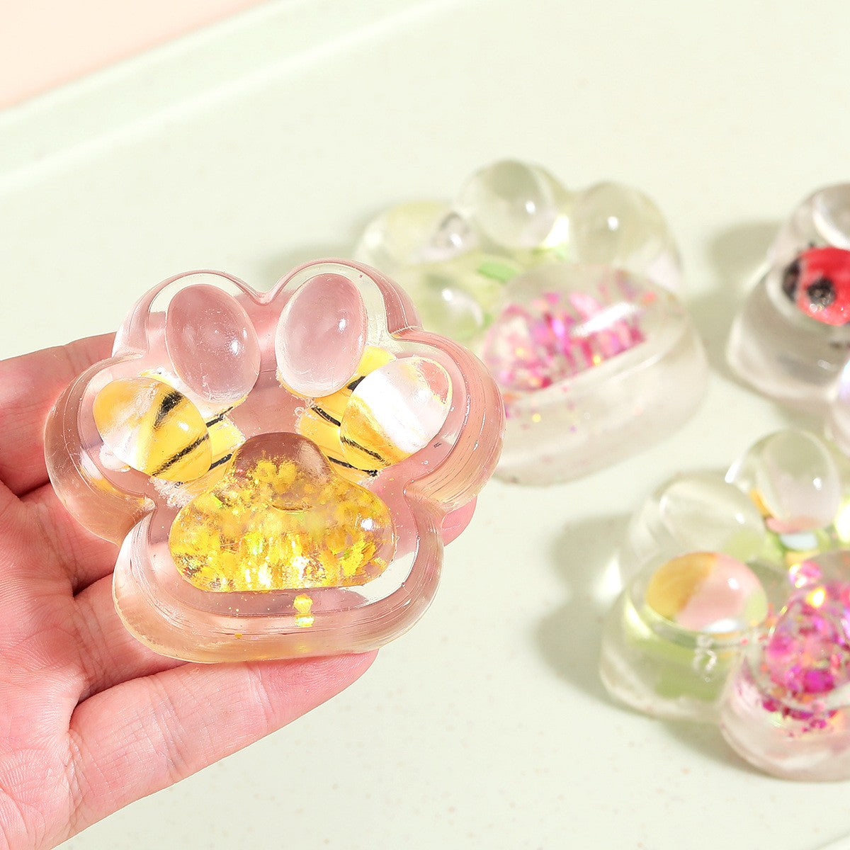 Jucarie Antistres Squishy, Kaveny, cu Revenire Lenta, Squeeze Pinch Family, Model Cat Paw, 6.5 x 7 cm, din Tpr, 4-6 Ani, Model 7 Insecte, Transparent