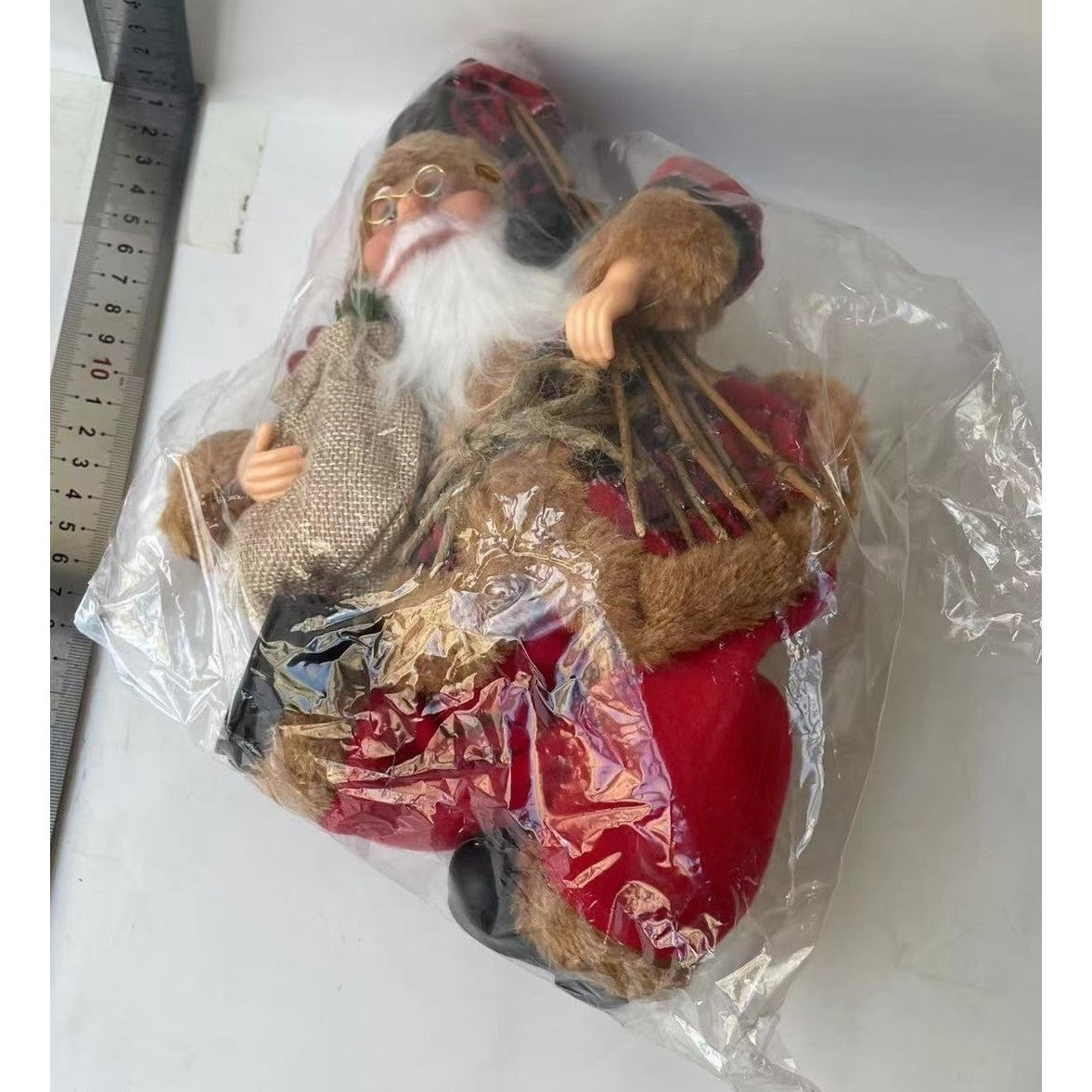 Figurina Decorativa Craciun, Kadeny, Mos Craciun Asezat cu Surcele la Brat, 35 x 18 x 20 cm, Material Plastic+Textil, Interior/Exterior, Rosu/Maro